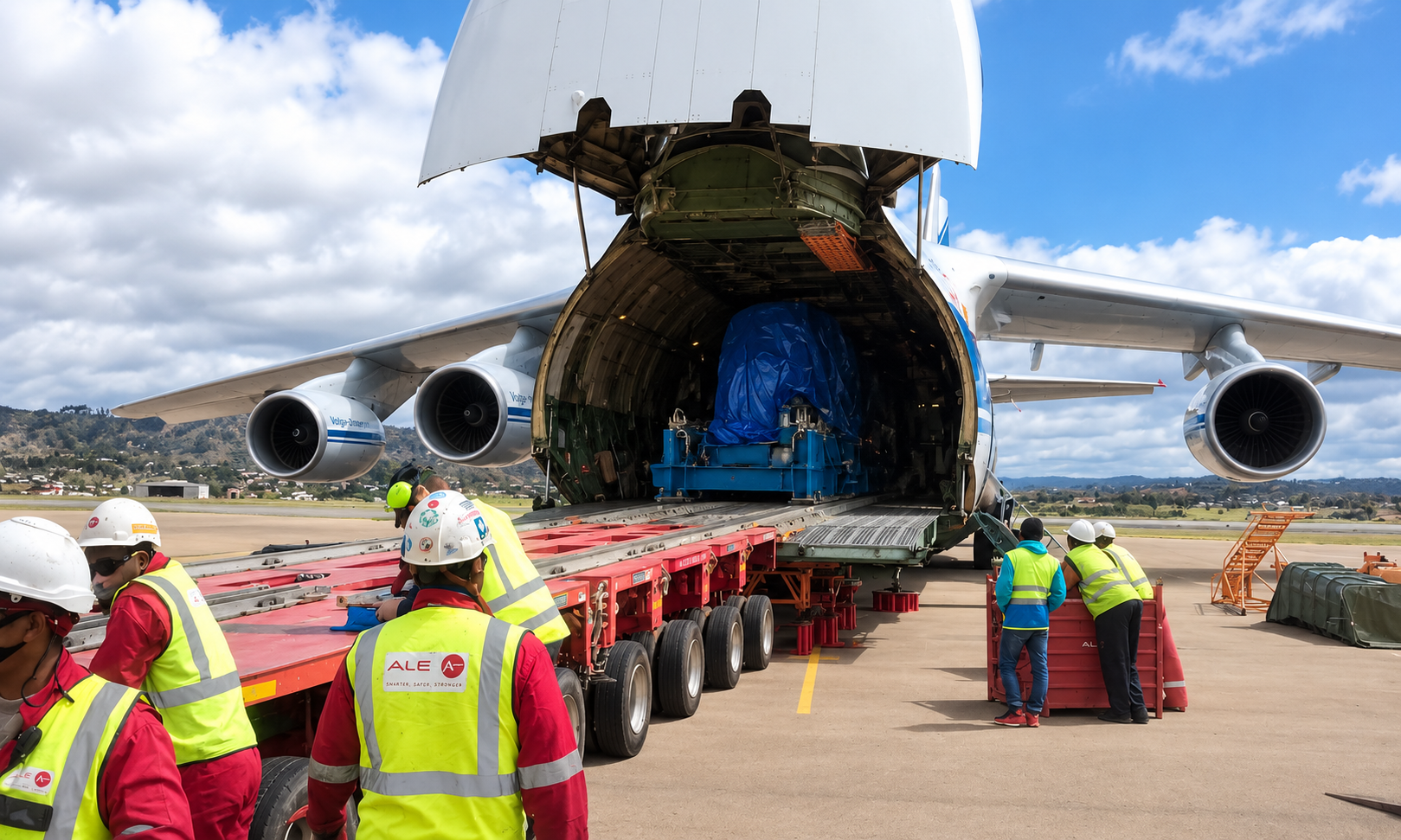 Heavy industrial cargo being loaded through an open-nose cargo aircraft